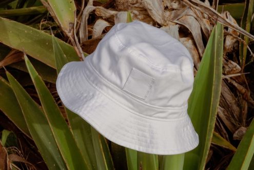 White bucket hat mockup on a natural outdoor background, perfect for showcasing apparel design in a realistic setting for designers.