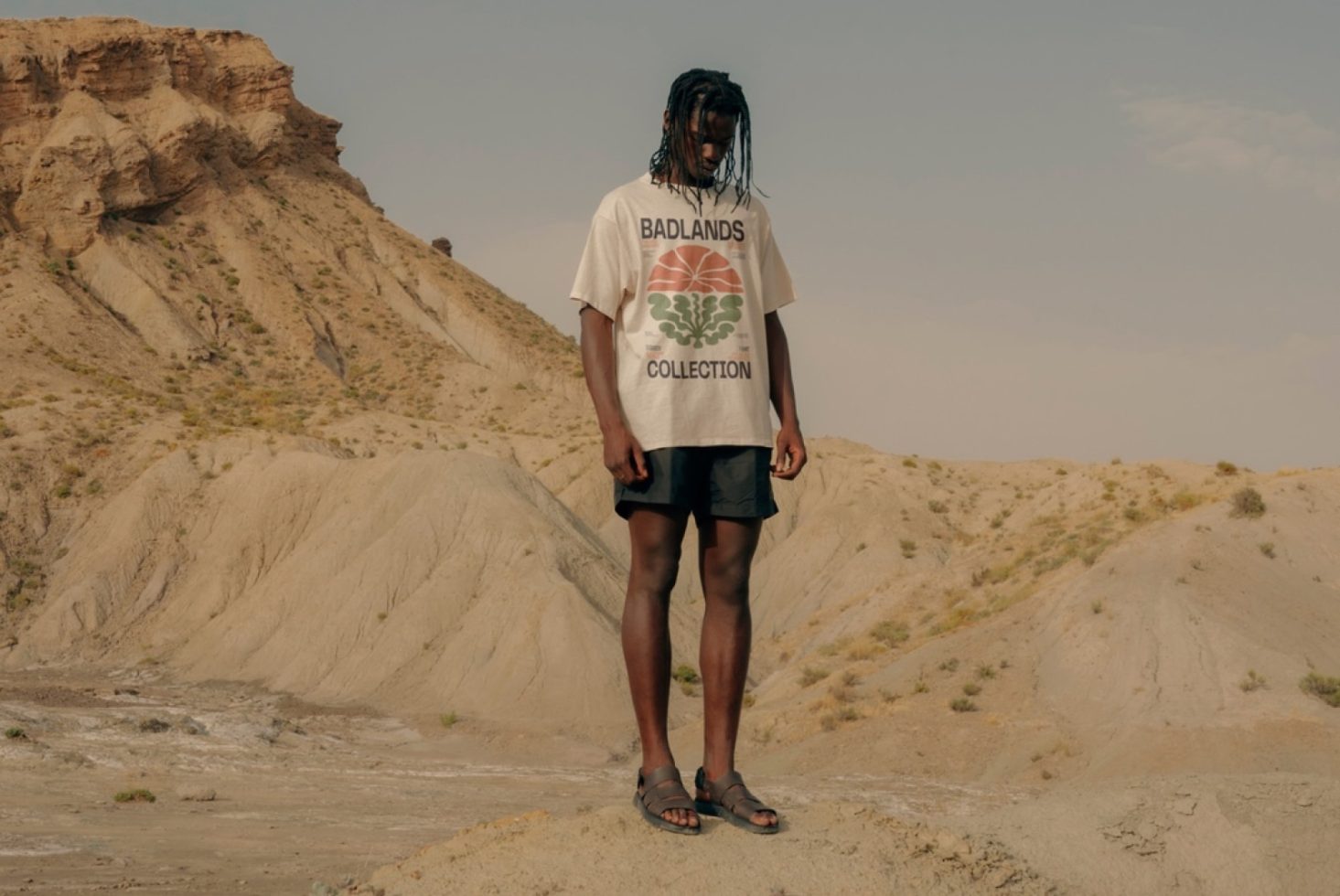 Fashion model in desert wearing graphic t-shirt for apparel mockup design showcasing, with natural outdoor backdrop.