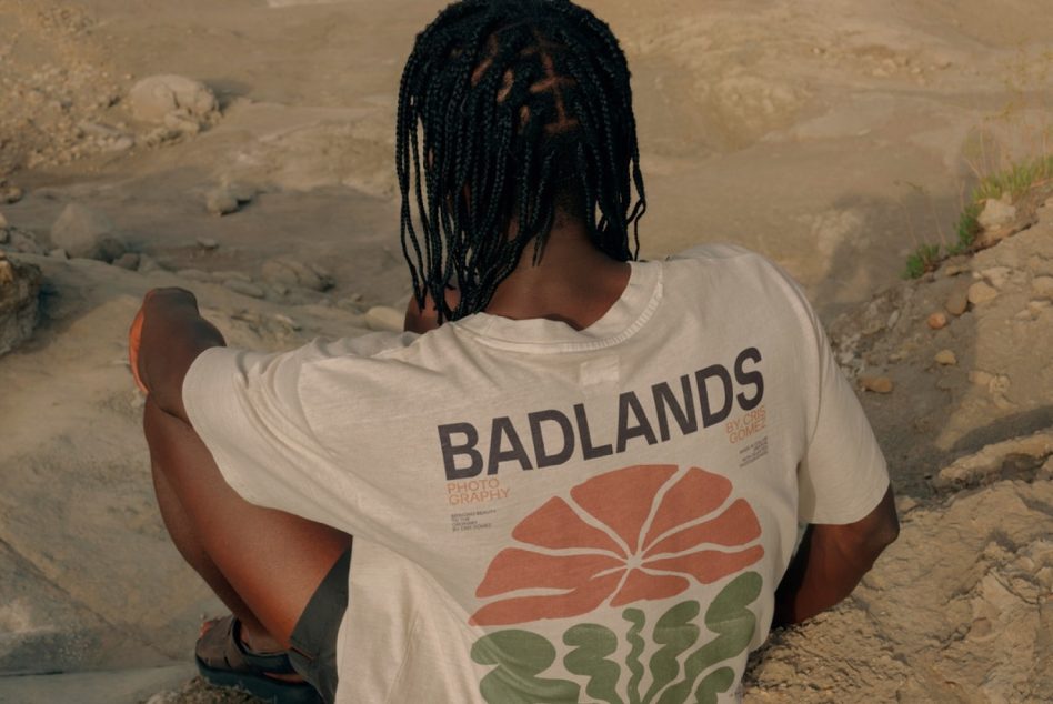 Person in a printed t-shirt sits outdoors, ideal for apparel mockup designs, showcasing graphic tees in a natural setting for designers.