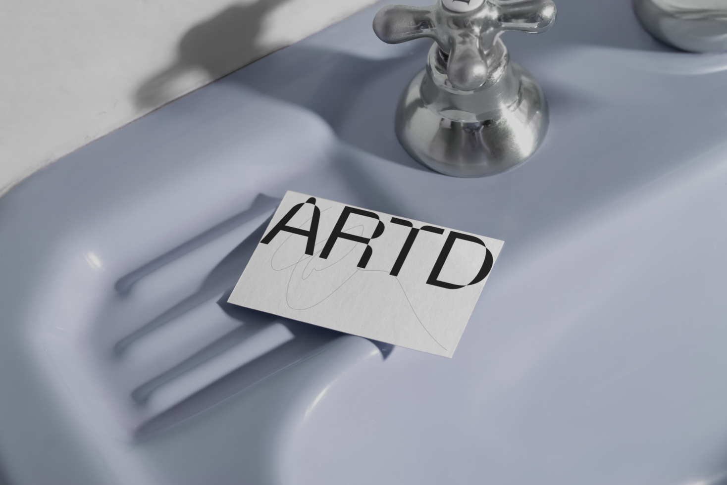 Creative card mockup with bold 'ART' typography on textured paper, set against a minimalistic bathroom sink with subtle shadows.