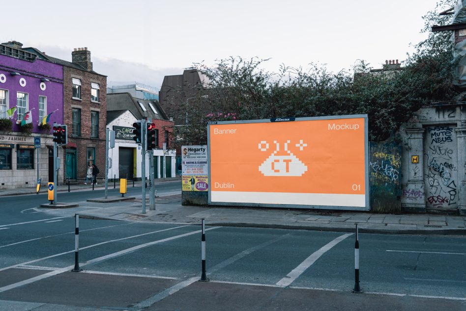 Street view with large digital billboard showing orange banner design in Dublin