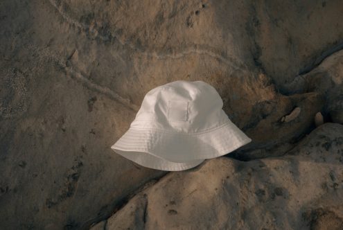 White bucket hat with blank patch on textured stone surface