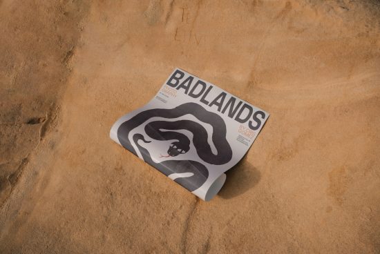 Magazine cover mockup with 'BADLANDS' title on sandy texture, showcasing natural earth tones, ideal for designers looking for realistic presentation.