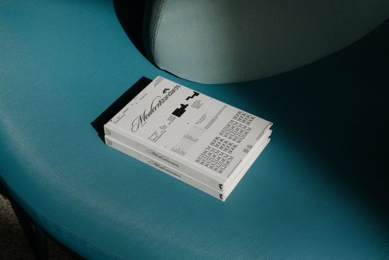 Stacked newspapers mockup on a teal chair for editorial design presentation, showcasing clean layout and typography.