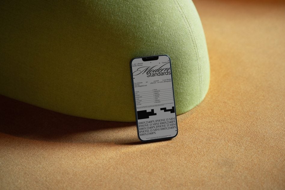 Phone displaying label design mockup propped against green rounded fabric shape