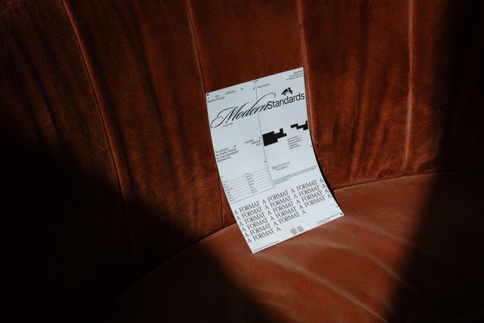 Folded poster mockup displaying Modern Standards design on rust velvet fabric