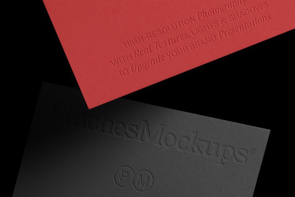 Red business card tilted over dark surface with embossed text visible