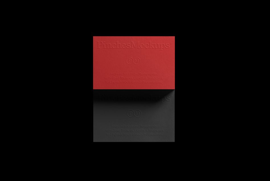 Red embossed business card mockup above dark textured card on black background with soft shadows