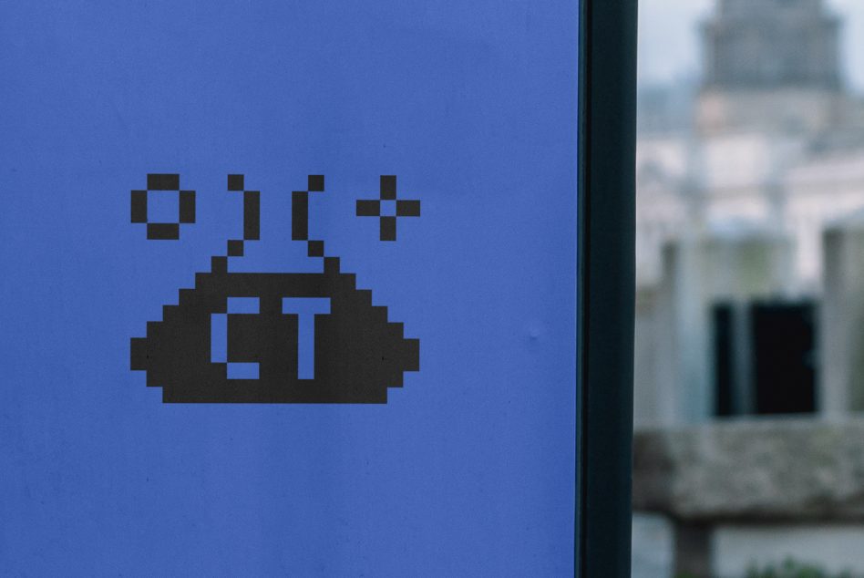 Blue metal surface showing dark pixelated UFO with geometric shapes