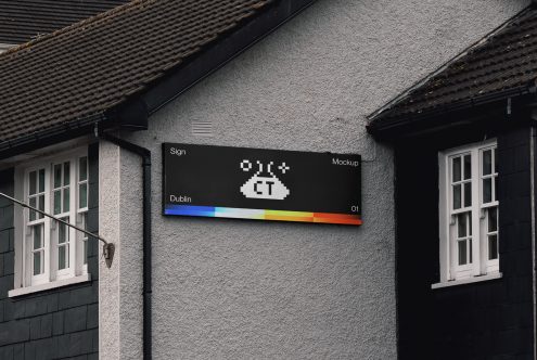 Black horizontal sign on grey wall with colorful spectrum stripe