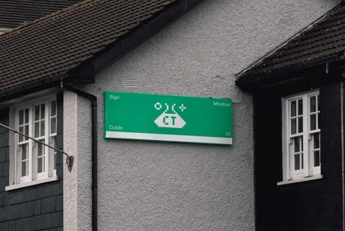 Green horizontal sign on grey wall with white pixel art cloud