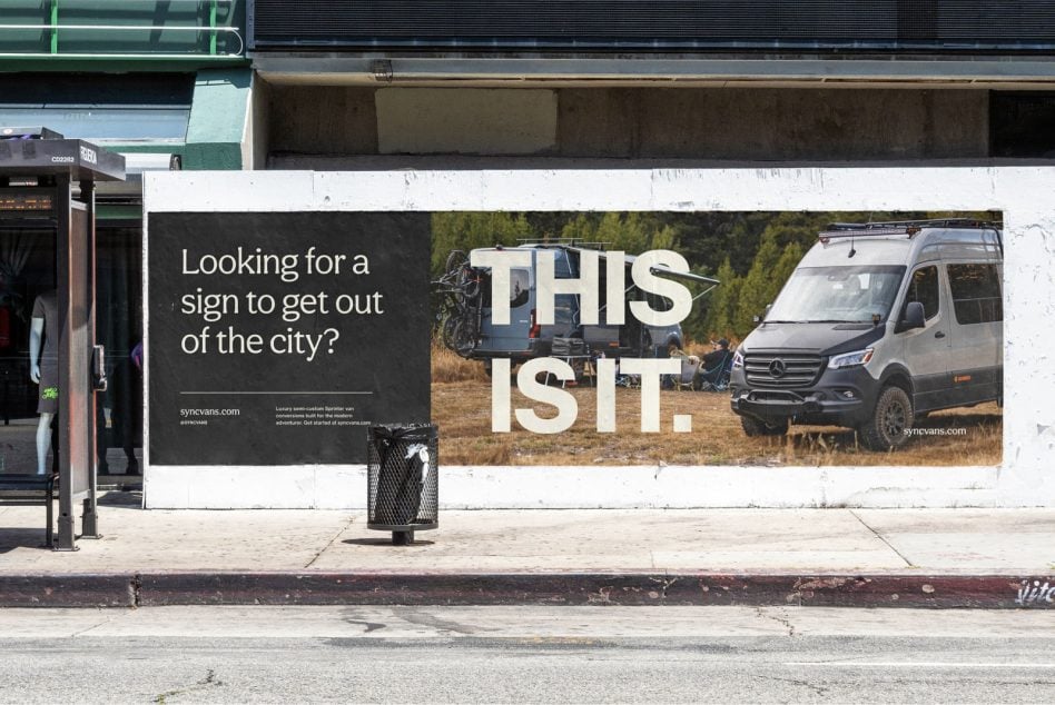 Street-level billboard mockup showing camping van with layered text overlay on city storefront