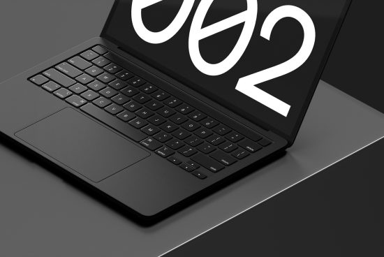 Laptop mockup with sleek design on dark background, featuring bold typography on screen, ideal for presenting digital fonts or graphics.