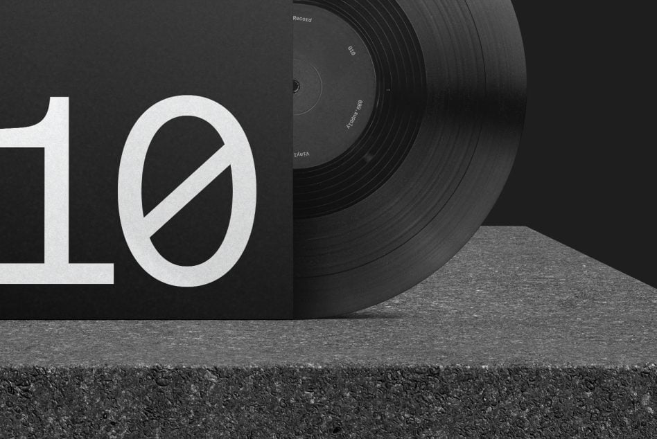 Vinyl record with large white number 10 on black album cover leaning against concrete