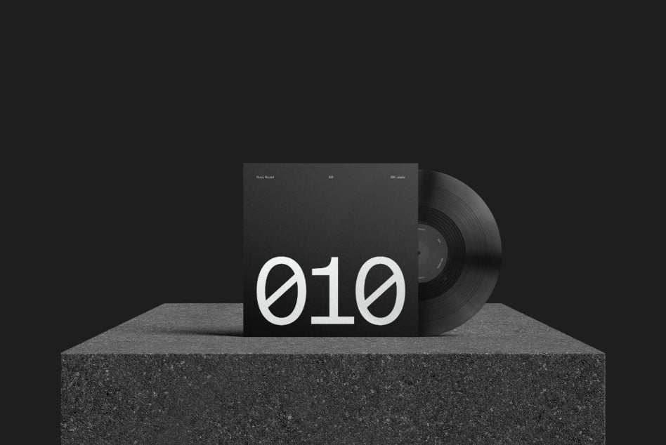 Vinyl record with white number 010 on black gatefold sleeve sitting on concrete ledge