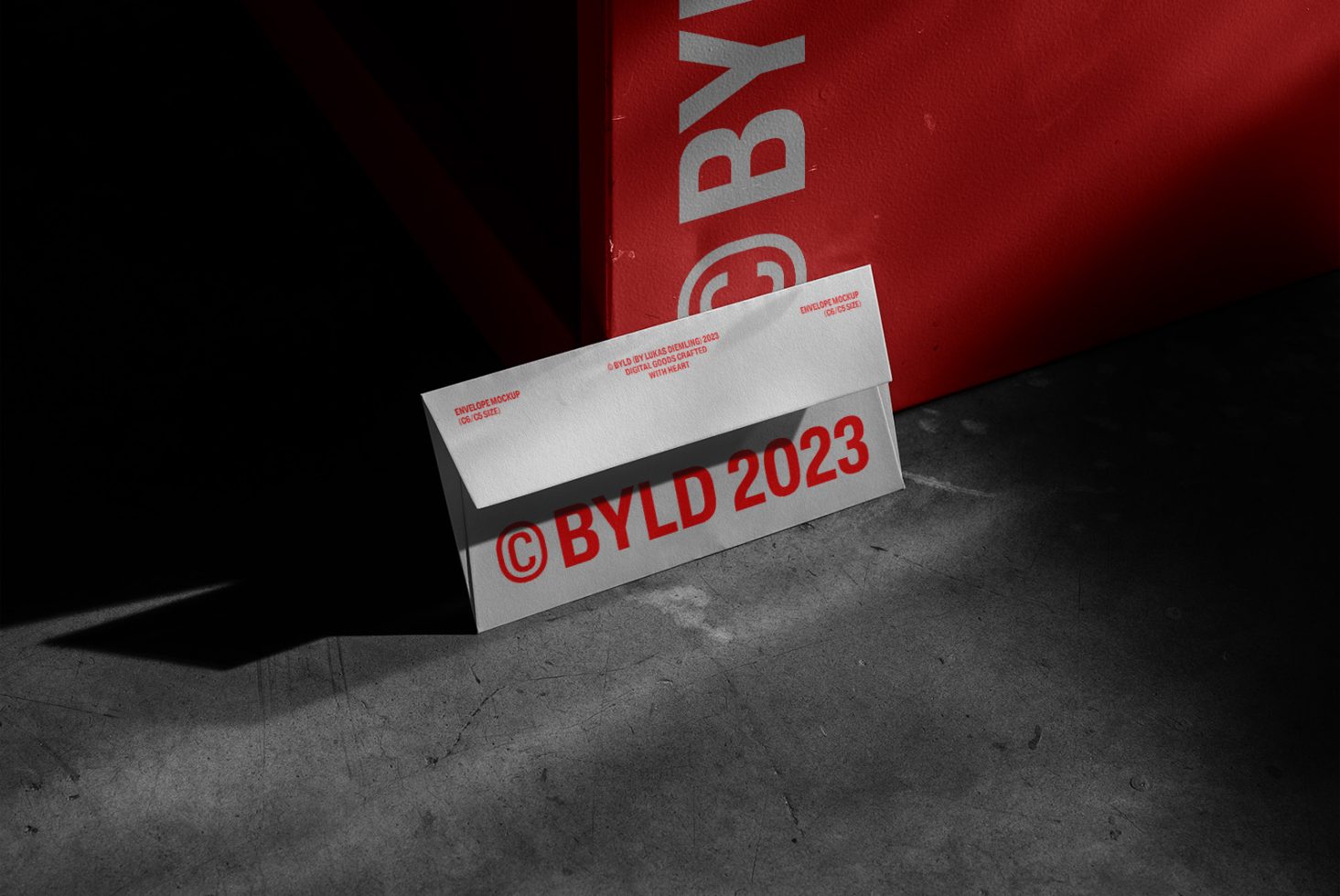 Business card mockup with red branding elements in a dark setting, showcasing corporate identity for graphic designers.