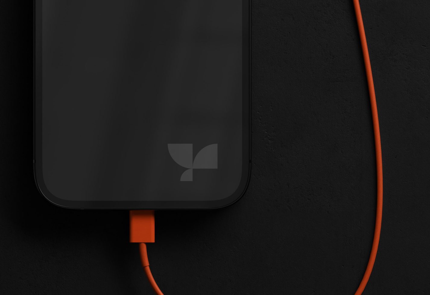 Smartphone mockup with blank screen on dark background with orange charging cable, ideal for app design presentation.
