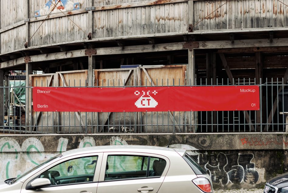 Red storefront banner on weathered warehouse with white car parked below