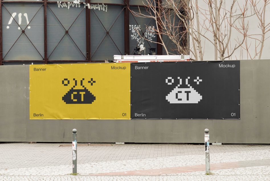 Two side by side outdoor banners, yellow left with dark pixel alien, charcoal right with white version