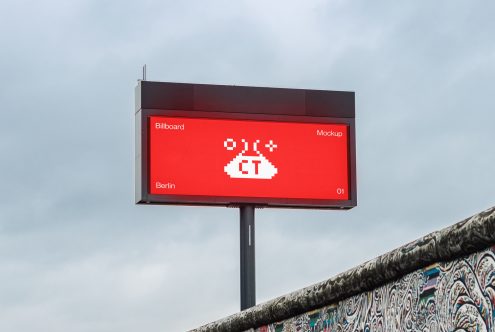 Red illuminated billboard with white pixel alien design, mounted on concrete pole