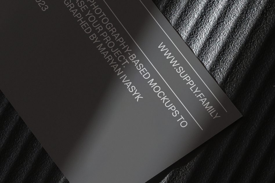 Black business card mockup on textured fabric with embossed text detail
