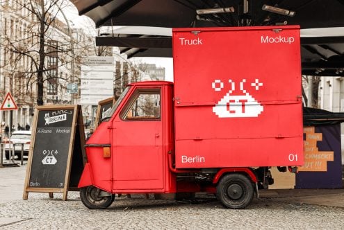 Red delivery truck with white pixelated logo on cargo box parked on Berlin street