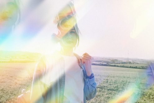 Woman in a field with prismatic light effect for Photoshop overlay templates, artistic outdoor portrait, mockup for design projects.