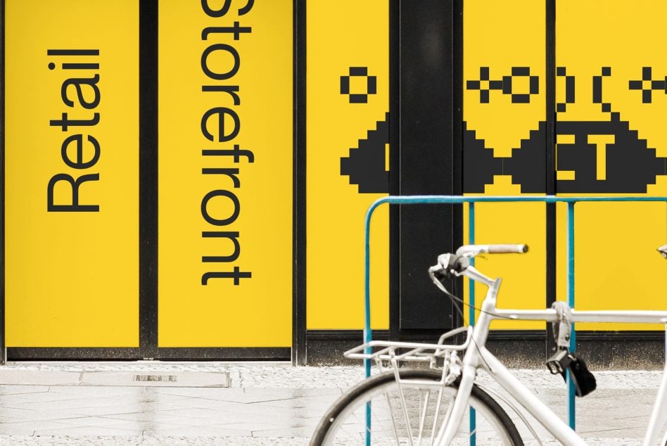 White bike parked in front of yellow storefront with pixel art logo