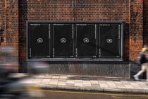 Street billboard mockup with four dark panels stacked horizontally on brick