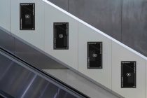 Multiple dark digital screen mockups scattered across modern gray wall