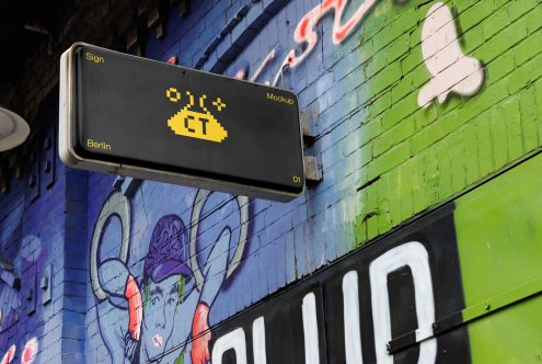 Black horizontal sign with yellow pixel taco on colorful graffiti wall