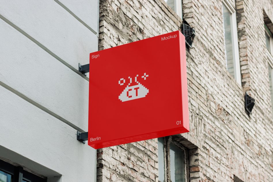 Red wall-mounted sign with pixel taco logo on brick storefront