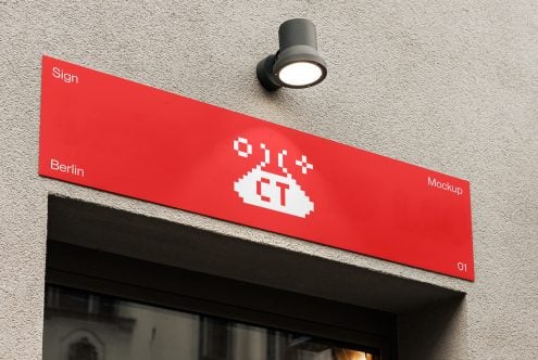 Red angled sign with white pixel logo mounted on concrete wall
