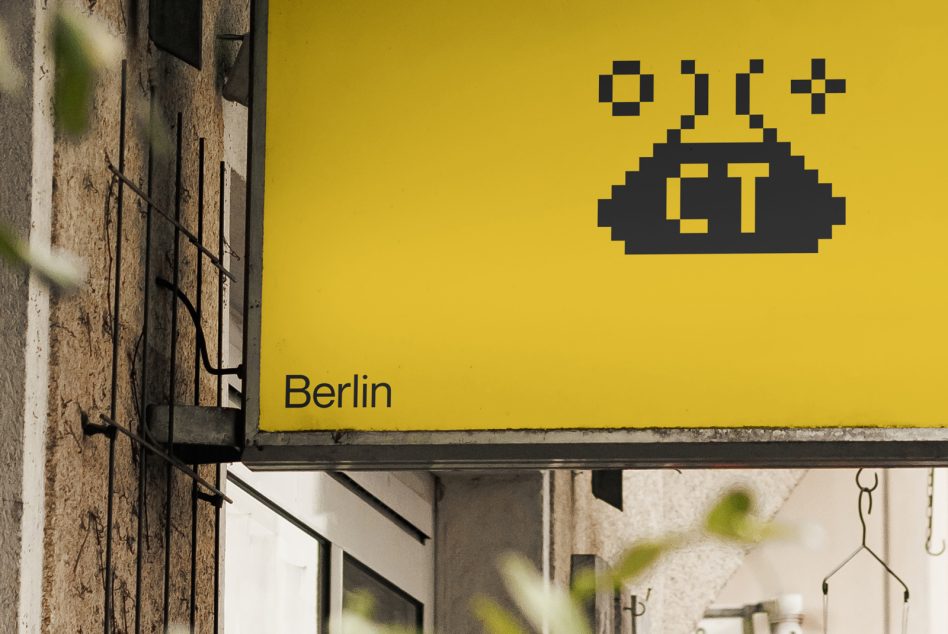 Yellow storefront billboard with black pixelated logo displayed above street level