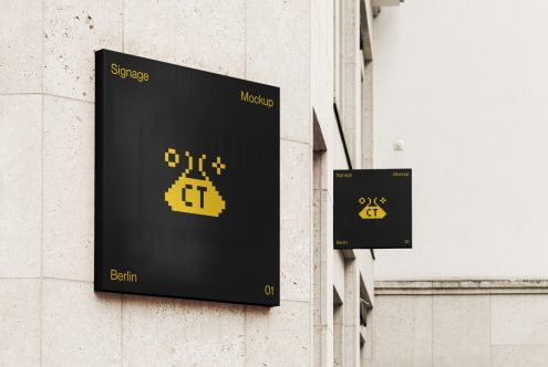 Large black signage with yellow pixelated logo next to smaller matching sign on wall