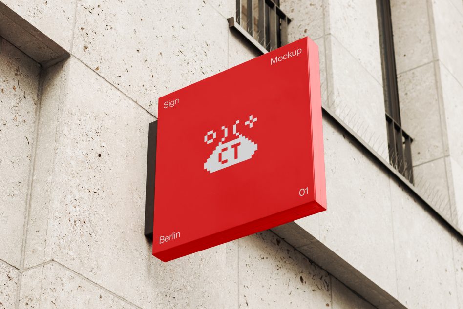 Bright red 3D box sign with white pixelated logo on textured concrete wall