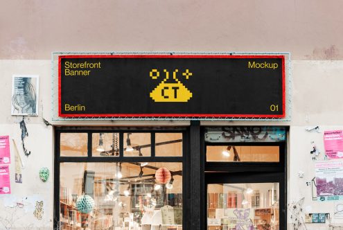 Black storefront banner with yellow type on shop window display
