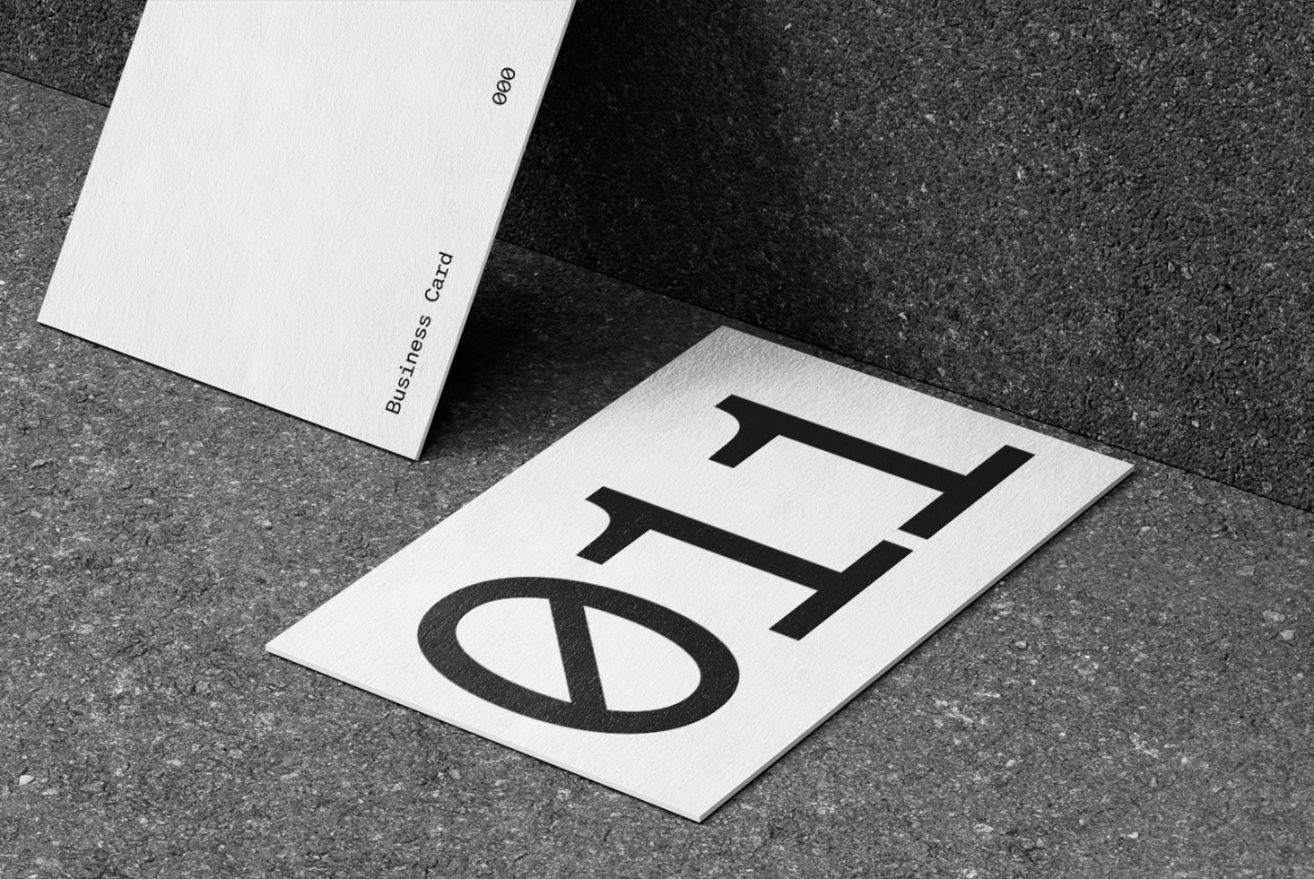 Elegant business card mockup on concrete texture for graphic designers, showcasing custom typography and logo design.