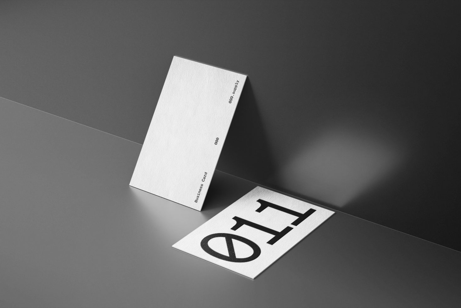 Elegant business card mockup on a dark surface with textured paper and minimalistic design, perfect for designers showcasing professional branding.
