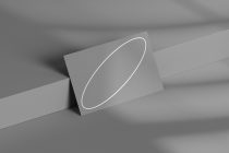Gray business card with white oval outline on geometric background