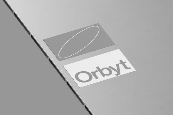 Minimalistic grey laptop mockup with elegant silver branding logo for design presentation and portfolio showcase.