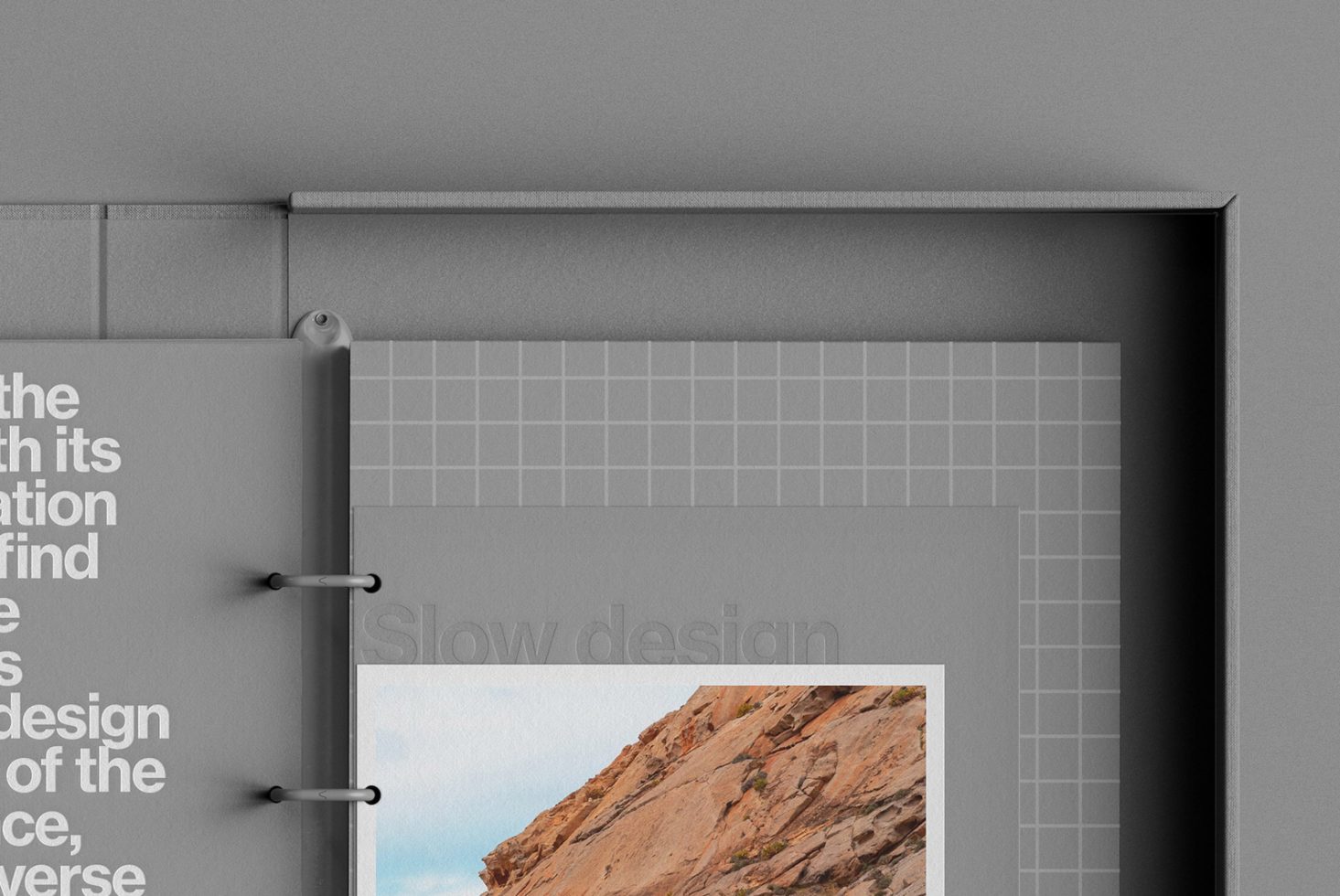 Grey portfolio mockup with binder clips and text overlay, showcasing design space with grid background and photo insert. Perfect for presentations.