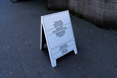 A-frame sidewalk sign mockup in white on dark pavement with rounded corner design