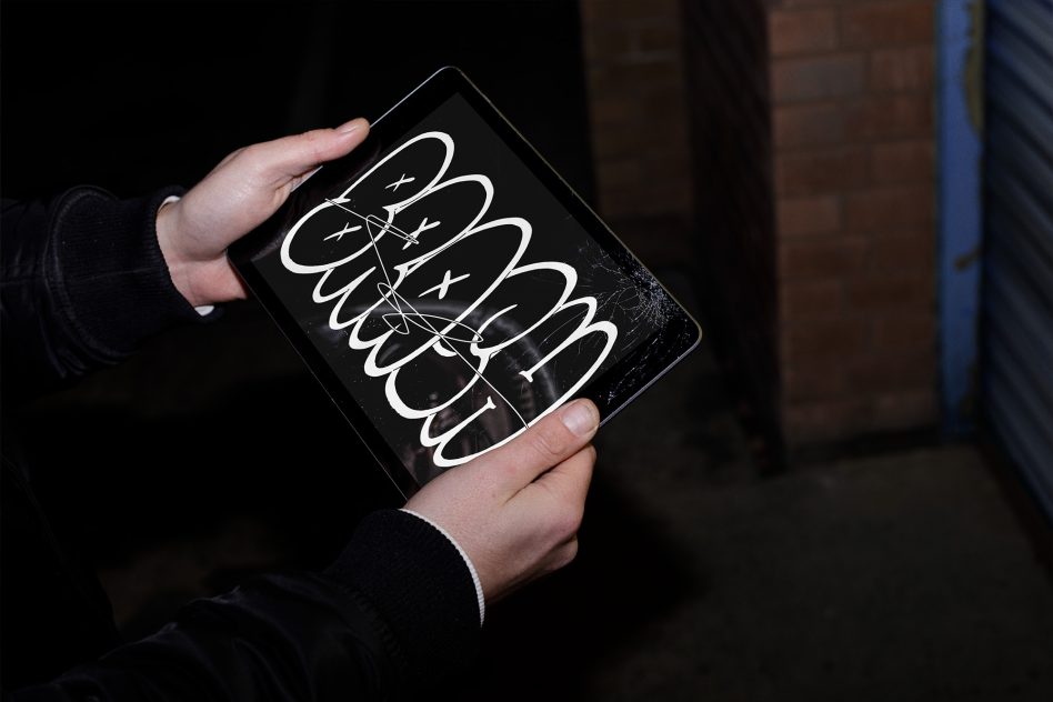 Black tablet held in hands displaying white hand-drawn oval shapes with connecting lines