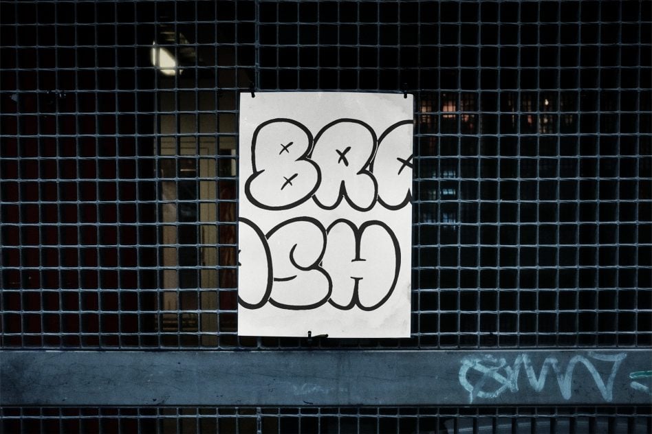 White poster with bubble letter graffiti tagged with X marks on metal gate