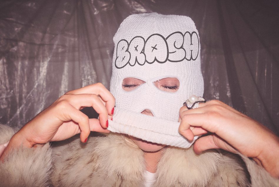 Person in white balaclava with bubble letter outline design on forehead face covering