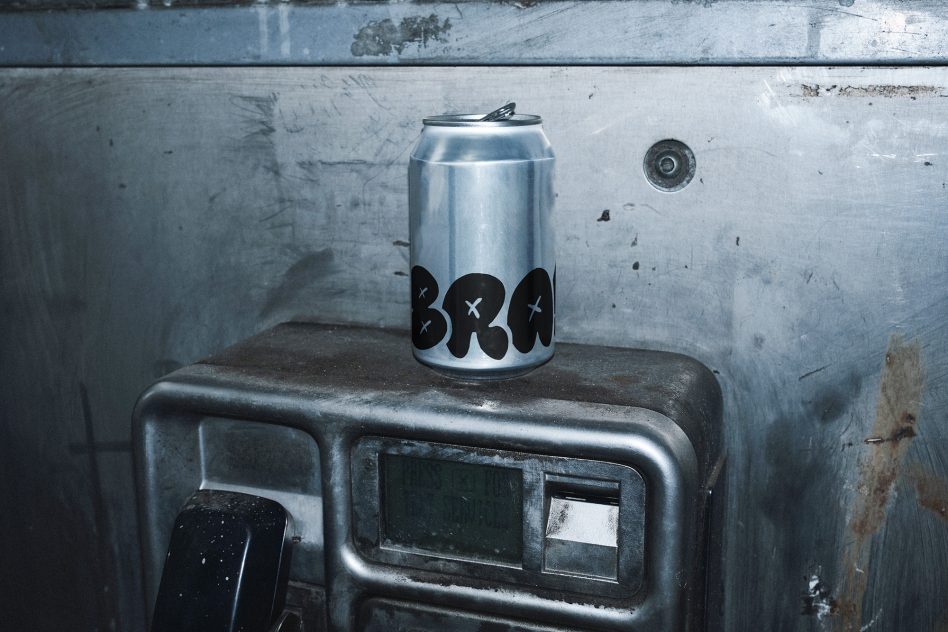 Silver aluminum can with minimal black design on industrial metal surface