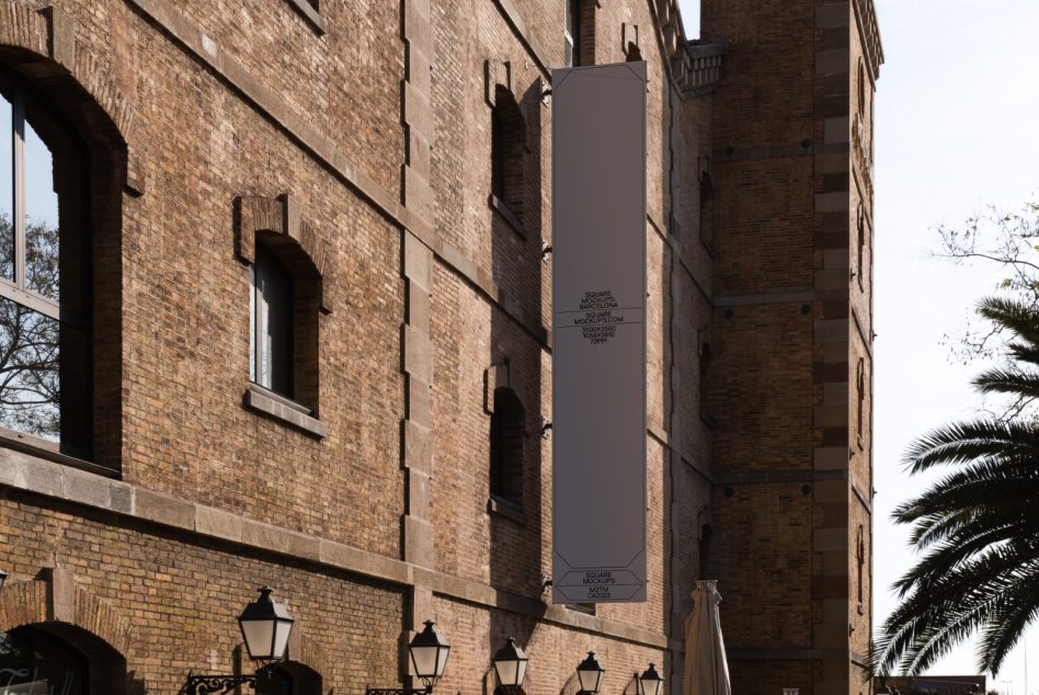 Tall vertical banner mockup in taupe hanging on brick building facade
