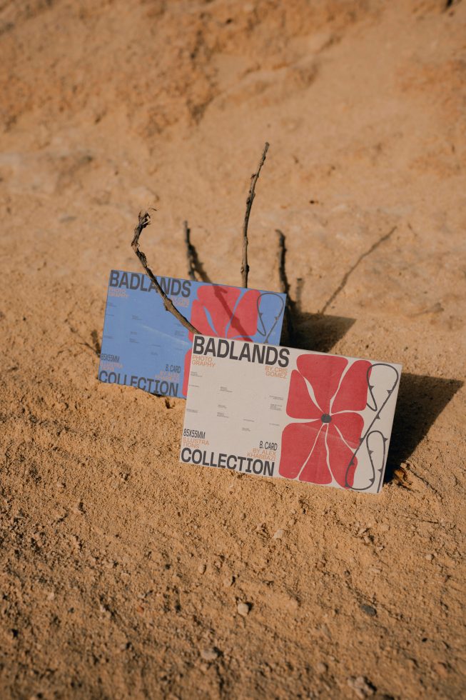 Business card mockups with artistic designs set on textured sand, showcasing graphic design and print layout for creative branding.