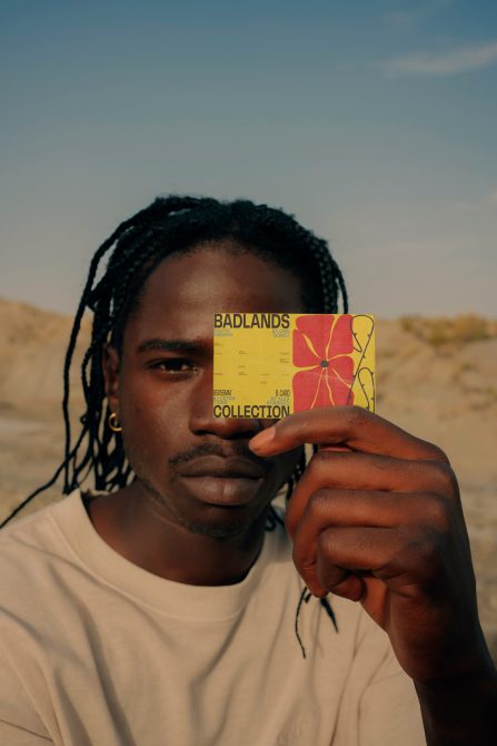 Young man holding a designer business card mockup in front of his face, showcasing graphic design and print template for branding.